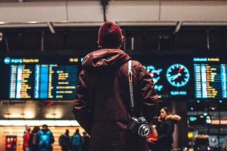 person looking up to the flight schedules by Erik Odiin courtesy of Unsplash.
