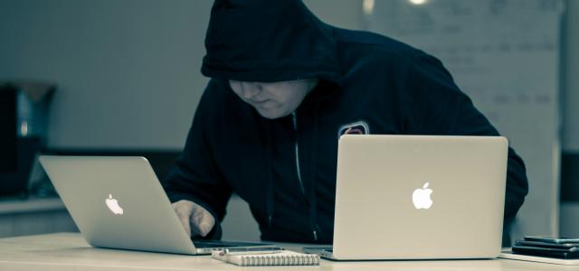 man in black hoodie using macbook by Azamat E courtesy of Unsplash.